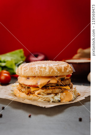 Double-layered chicken burger with melted cheese and fresh toppings Double-layered chicken burger with melted cheese and fresh toppings 119569473