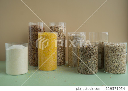 Refillable glass jar with raw grain porridge. Copy space Refill product format eco-friendly living. Filling reusable container Whole spelt grain species. High protein fiber-rich vegan plant based food Refillable glass jar with raw grain porridge. Copy space Refill product format eco-friendly living. Filling reusable container Whole spelt grain species. High protein fiber-rich vegan plant based food 119571954