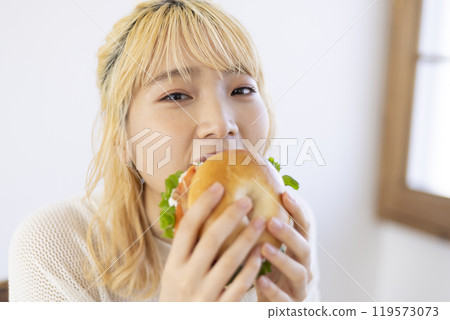 Woman eating a bagel 119573073