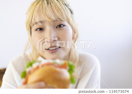 Woman eating a bagel 119573074