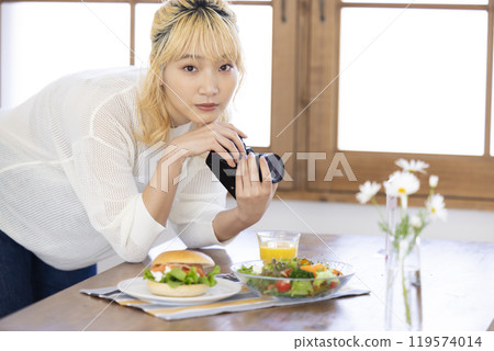 Woman taking a photo of food with a camera 119574014