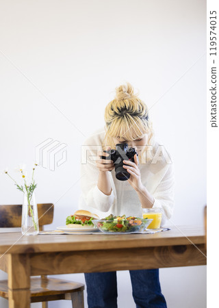 Woman taking a photo of food with a camera 119574015