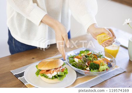 將檸檬擠入沙拉中的女人的手 119574169