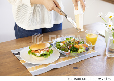 Woman's hands grating cheese onto salad Woman's hands grating cheese onto salad 119574170