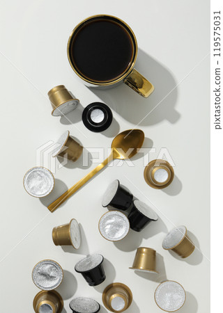 Coffee capsules, cup and spoon on white background, top view Coffee capsules, cup and spoon on white background, top view 119575031
