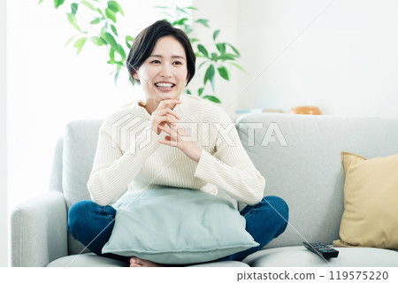 Woman relaxing in the living room 119575220