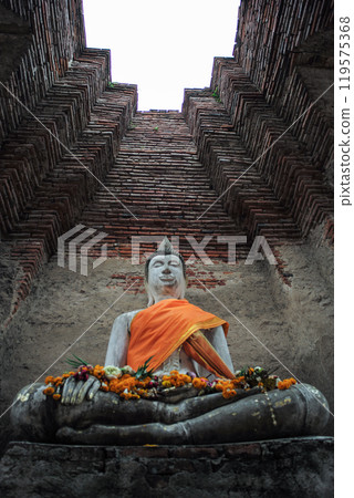 High angle view of Buddha statue with high red brick wall in background High angle view of Buddha statue with high red brick wall in background 119575368