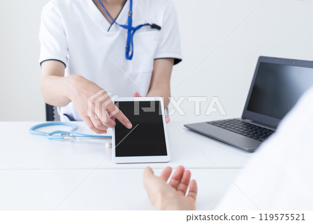 一位女醫務人員操作平板電腦並解釋 119575521