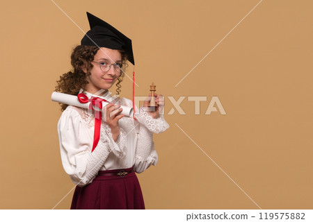 Graduate holding diploma scroll and chess king piece. Graduate holding diploma scroll and chess king piece. 119575882
