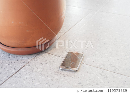 A smartphone accidentally dropped on the pavement, just inches away from a womans feet 119575889