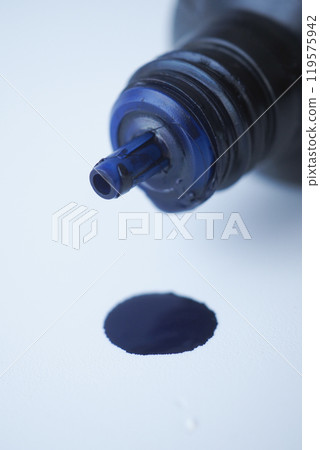 A Captivating CloseUp of a Dark Blue Ink Droplet Emerging from a Bottle as It Falls A Captivating CloseUp of a Dark Blue Ink Droplet Emerging from a Bottle as It Falls 119575942