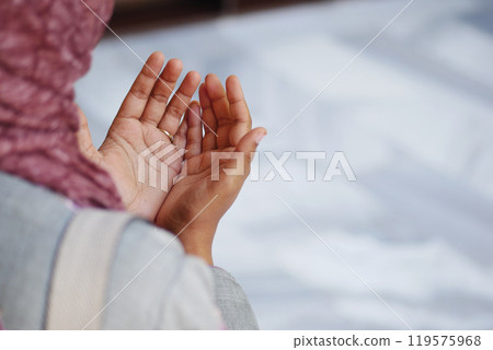 Muslim young woman in hijab is praying in mosque. Muslim young woman in hijab is praying in mosque. 119575968