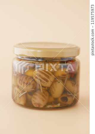 A Beautifully Presented Jar of Marinated Olives Complete with a Colorful Garnish on Top 119575973