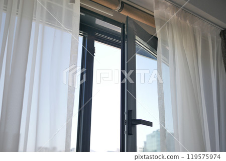 A Beautiful Sunlit Window Featuring Sheer Curtains in a Contemporary and Modern Room A Beautiful Sunlit Window Featuring Sheer Curtains in a Contemporary and Modern Room 119575974