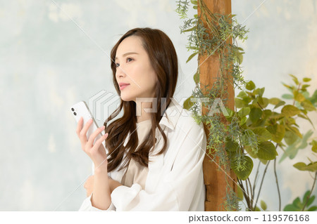 一位女士一邊看著智慧型手機一邊思考 119576168