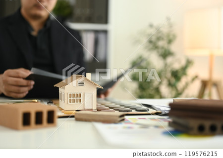 A small house model and color swatches on architect desk. Home improvement concept 119576215