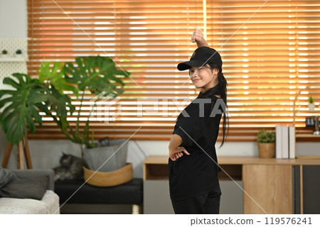 Smiling teenage girl enjoying freestyle dance practice in living room. People and leisure activity concept 119576241