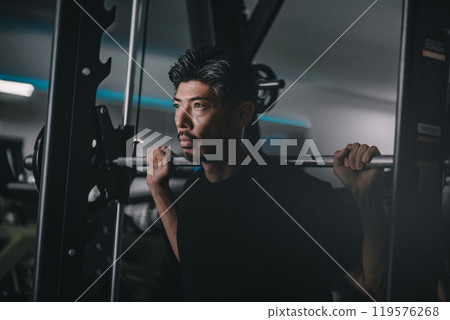 A man in his 40s working out his lower body at the gym A man in his 40s working out his lower body at the gym 119576268