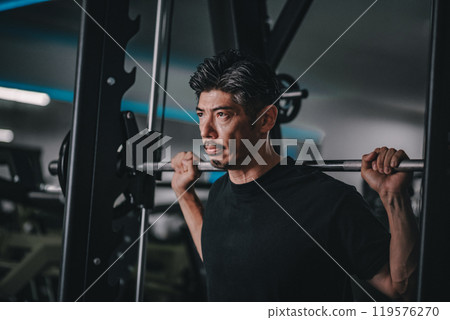A man in his 40s working out his lower body at the gym 119576270