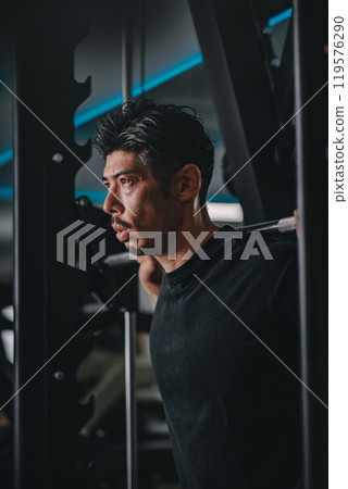 A man in his 40s working out his lower body at the gym 119576290