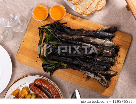 Catalan festive grilled calcots with butifarra sausage and romesco sauce Catalan festive grilled calcots with butifarra sausage and romesco sauce 119576555