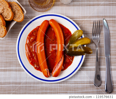 Two Viennese sausages with saftgoulash served on plate 119576631
