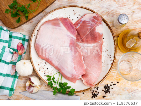 Spanish Secreto de cerdo - raw pork cinch with parsley and peppers in plate Spanish Secreto de cerdo - raw pork cinch with parsley and peppers in plate 119576637