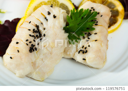 Closeup of codfish steamed and served with herbs and lemon Closeup of codfish steamed and served with herbs and lemon 119576751