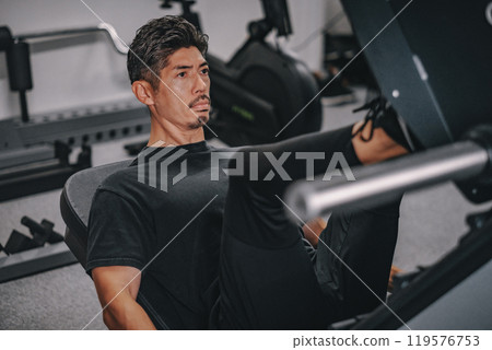A man in his 40s working out at the gym 119576753