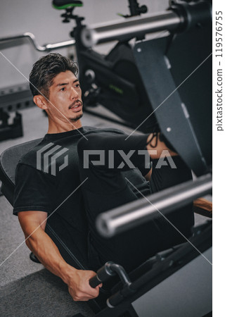 A man in his 40s working out at the gym 119576755
