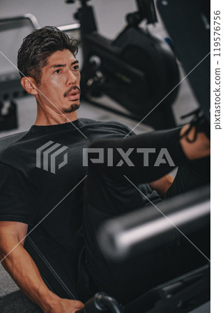 A man in his 40s working out at the gym 119576756