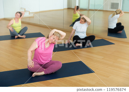Three women are sitting in a lotus pose Three women are sitting in a lotus pose 119576874