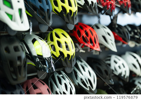 Bicycle helmets in row in sports store 119576879