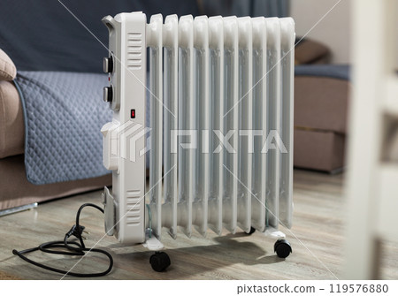 Electric oil heater on floor in room 119576880