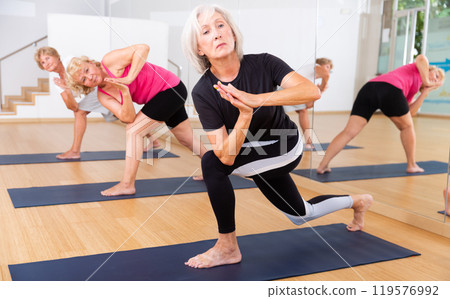 Mature women perform the exercise in the twisted side angle pose 119576992