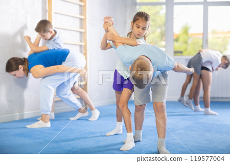 Girls and boys of performing protection with wring hands during training in self-defense Girls and boys of performing protection with wring hands during training in self-defense 119577004