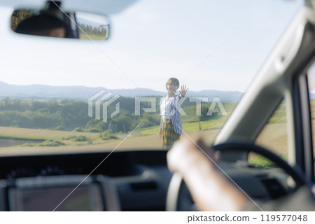 Young woman walking out of a car 119577048