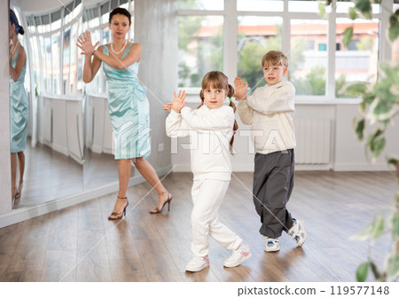 Preteen couple practicing swing dance in choreography studio with teacher Preteen couple practicing swing dance in choreography studio with teacher 119577148