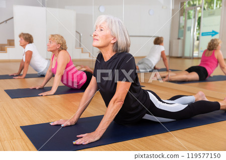 Mature women exercising cobra pose indoors 119577150