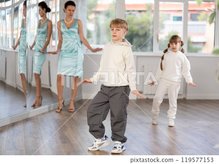 Tween boy mimicking comedic stroll of Charlie Chaplin during dance rehearsal Tween boy mimicking comedic stroll of Charlie Chaplin during dance rehearsal 119577153