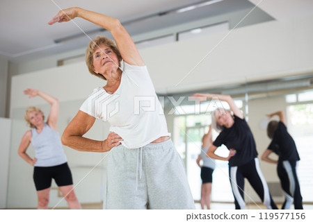 Portrait of mature energetic woman practicing active dancing at a group lesson Portrait of mature energetic woman practicing active dancing at a group lesson 119577156