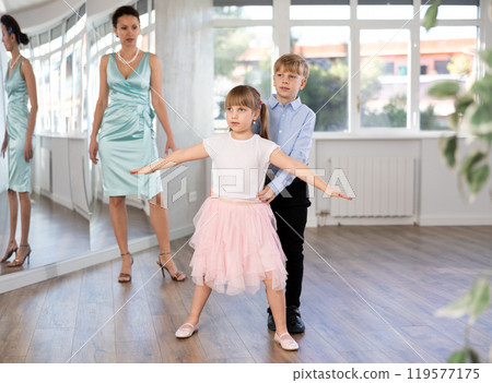Boy and girl in pair train to dance contemporary vigorous waltz during classes. 119577175