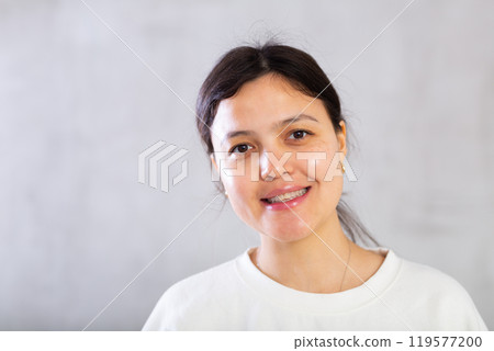 Closeup portrait of smiling young woman on gray background Closeup portrait of smiling young woman on gray background 119577200