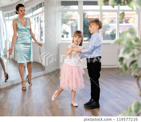 Preteen boy and girl refining slow foxtrot technique in dance hall Preteen boy and girl refining slow foxtrot technique in dance hall 119577216