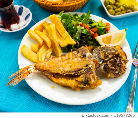 Roasted lionfish with potatoes and fresh greens Roasted lionfish with potatoes and fresh greens 119577260