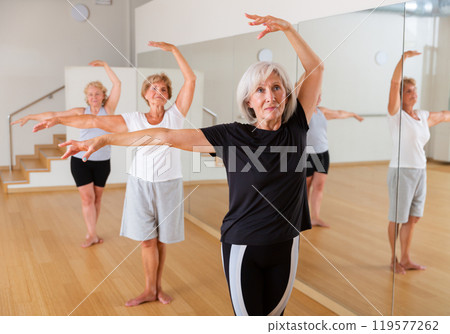 Group of elderly women standing in the 3rd position of the ballet stand Group of elderly women standing in the 3rd position of the ballet stand 119577262