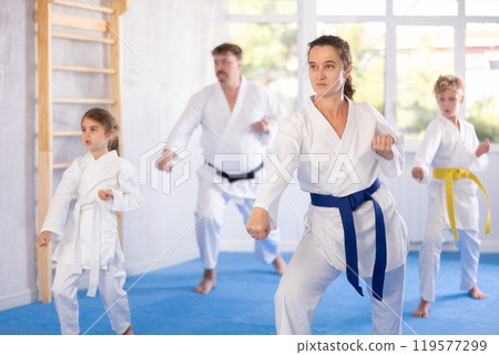 Family with children training karate techniques 119577299