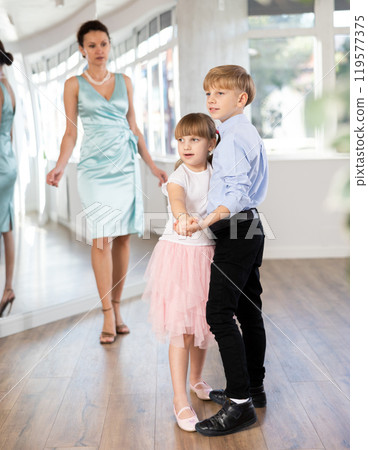Boy and girl in pair train to dance contemporary vigorous waltz during classes. 119577375