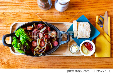 Polish sausages fried in onions 119577394