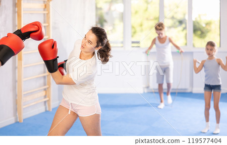 Married couple training together at boxing lessons in gym Married couple training together at boxing lessons in gym 119577404